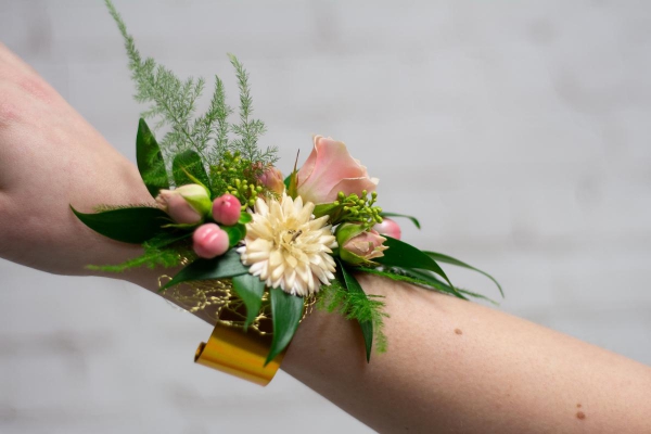 Mixed flower corsage on gold cuff.